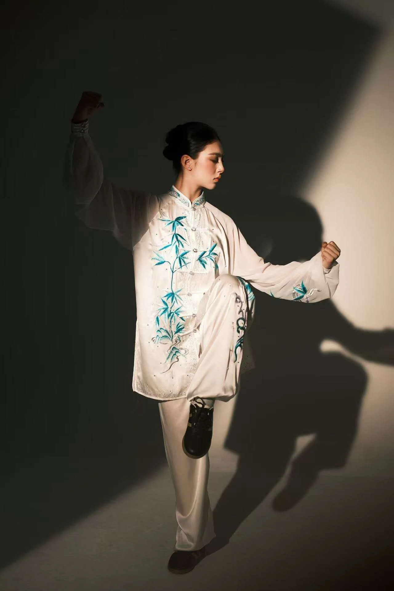 Annie Harris — wushu editorial, standing kick pose, dark teal-toned background